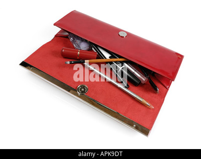 Open fancy red stylish handbag full of makeup accessories Stock Photo