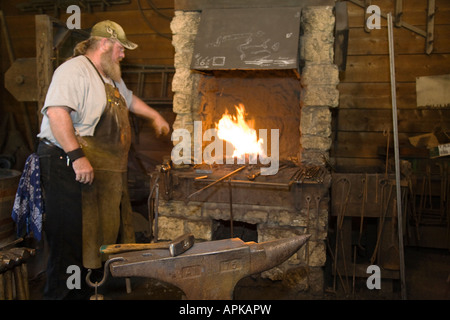 ILLINOIS Grand Detour Blacksmith standing by forge blacksmith shop at John Deere Historic site anvil and tools Stock Photo