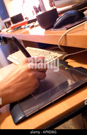 Working on a computer with a graphical pen tablet Stock Photo