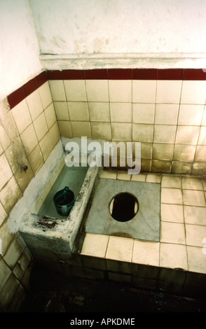 Hole in the ground squat toilet at a public restroom Stock Photo - Alamy