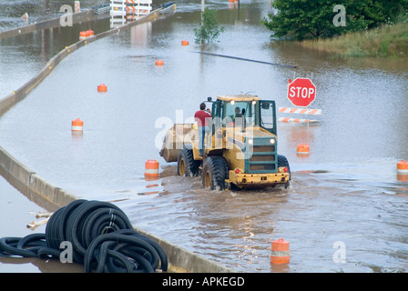 Men riding in tractor through flooded road, Pennsylvania, USA Stock Photo