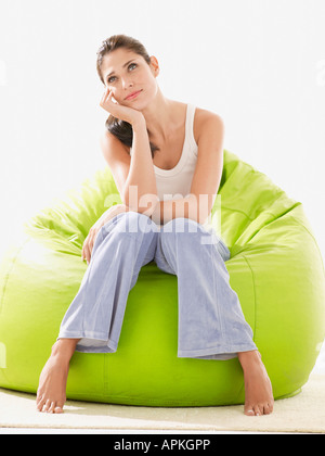 Young woman daydreaming on beanbag Stock Photo