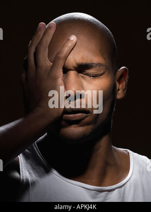 Young man with hand on face Stock Photo