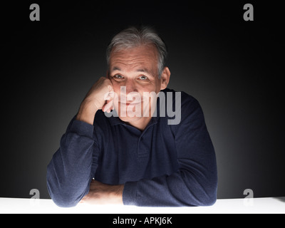 Mature man leaning against his hand (portrait) Stock Photo