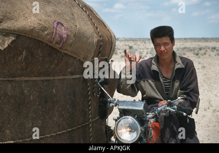 Kazakh herdsman with a motorcycle besides a yurt, Kazakhstan, Kyzyl Kum Stock Photo