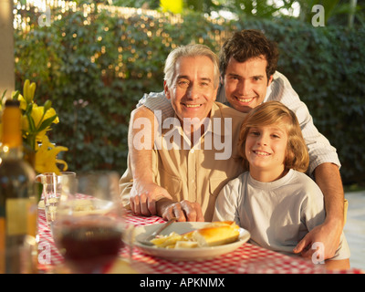 Three generation family of men by dining table (portrait) Stock Photo