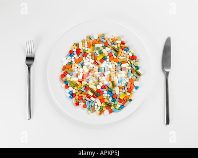 Mixed pills on white plate (close-up, directly above) Stock Photo