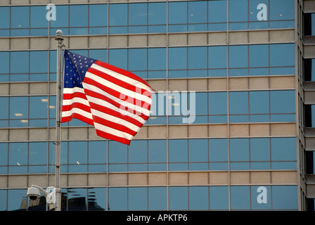 The United States Flag flies against a background of windows in downtown Indianapolis Indiana IN Stock Photo