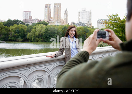 Man photographing woman on footbridge Stock Photo
