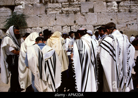 Jewish men wrapped with traditional Talit shawl praying at the Western Wall or Kotel in East Jerusalem Israel Stock Photo