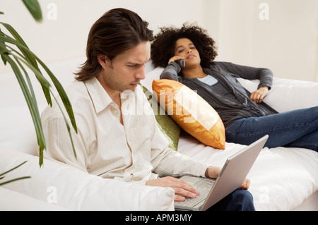 Young man using laptop and Woman talking on the phone Stock Photo