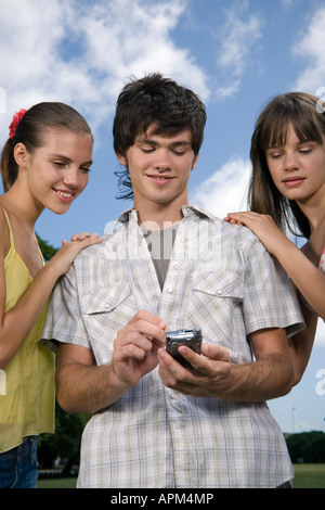 Teenagers using electronic agenda and celullar phone Stock Photo