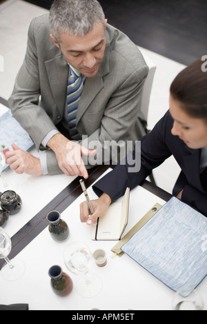 Two businesspeople making notes at dining table (high angle view) Stock Photo