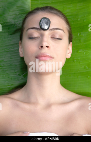 Young woman receiving hot stone therapy, directly above Stock Photo