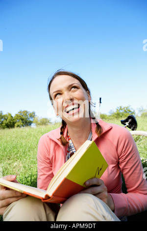 Young woman reading book in park Stock Photo