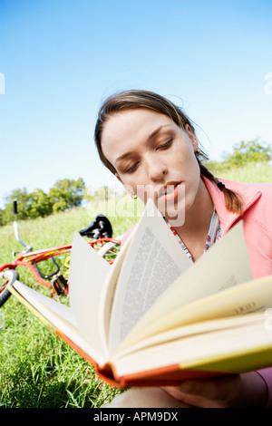 Young woman reading book in park Stock Photo