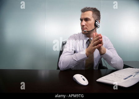 Businessman talking through telephone headset Stock Photo