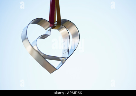 Two heart shaped cookie cutters hanging (close-up) Stock Photo