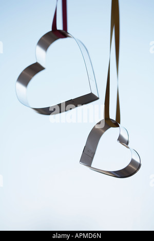 Two heart shaped cookie cutters hanging (close-up) Stock Photo