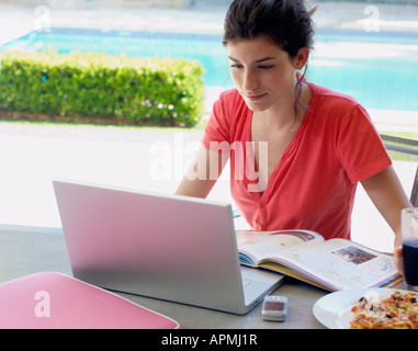 Woman studying and using laptop, snack on table (high angle view) Stock Photo