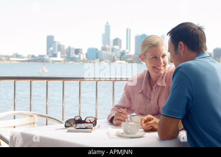 Mature couple drinking coffee in patio, city in background, Perth, Australia Stock Photo