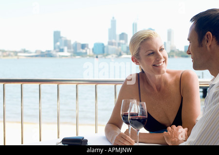 Mature couple drinking red wine, city in background Stock Photo