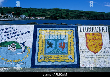 Ship's calling cards painted on the quayside at Horta marina, on Faial island in the Azores Stock Photo