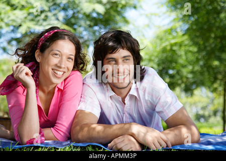 Young couple lying on blanket in park Stock Photo