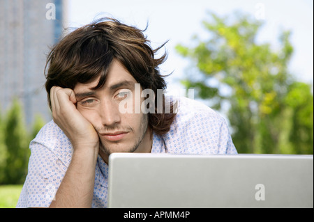 Bored young man using laptop Stock Photo