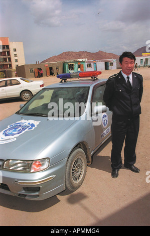 Policeman near the patrol car. Khovd aimak (administrative center). Khovd aimag (province). West Mongolia Stock Photo