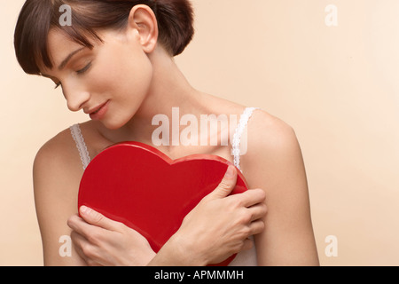Mid adult woman holding heart shaped chocolate box Stock Photo