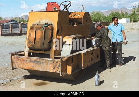 Workers fixing asphalt roller. Khovd aimak (administrative center). Khovd aimag (province). West Mongolia Stock Photo