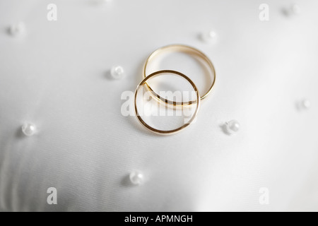 Two golden wedding rings on cushion