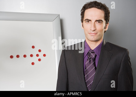 Businessman with arrow on flipchart Stock Photo