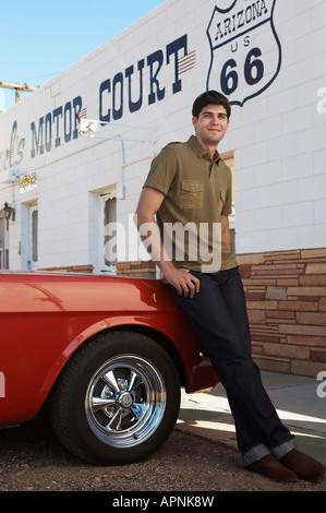 Young man leaning on car by motel, Arizona, USA Stock Photo