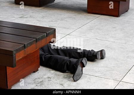 Low Section of Businessman Lying on Tiled Floor Stock Photo