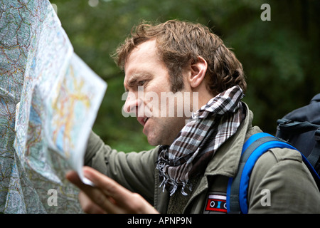 Male Hiker Reading Map in Forest Stock Photo