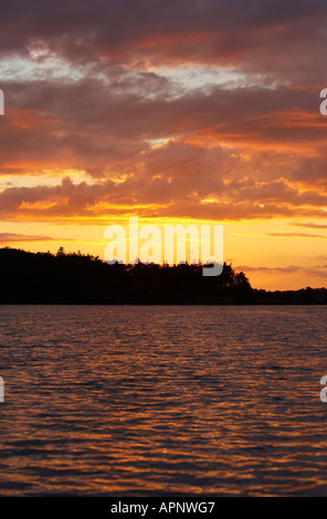 sunset in sky and on lake ripples Stoneyford Reservoir at sunset county antrim northern ireland Stock Photo