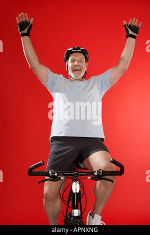 Senior male cyclist celebrating Stock Photo