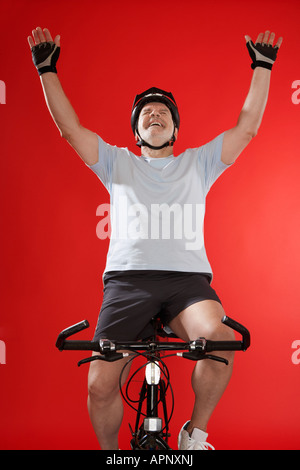 Senior male cyclist celebrating Stock Photo