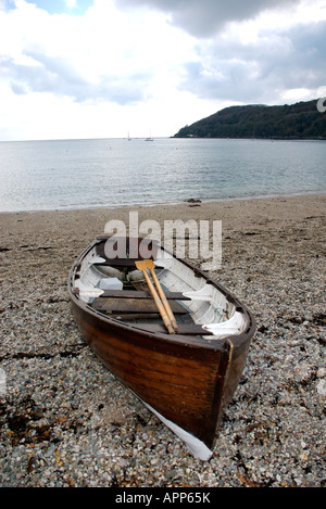 Wooden rowing boat on pebble beach Stock Photo