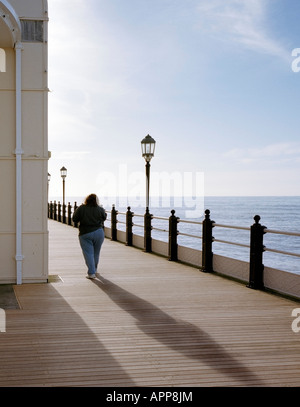 A women strolling along worthing Pier West Sussex England UK Stock Photo