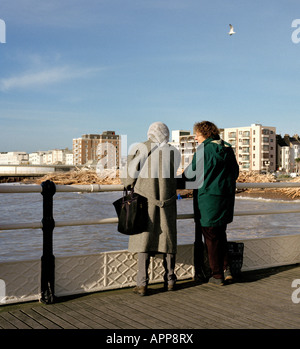 Two women chatting on worthing Pier West Sussex England UK Stock Photo