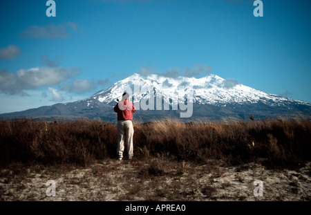 Photographer in the middle of tussock plains and Mount Ruapehu North Island New Zealand Stock Photo