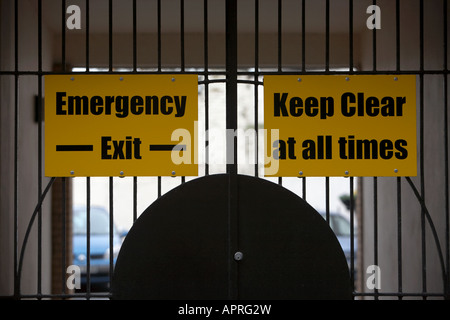 gates to private parking area with emergency exit keep clear at all times sign Belfast Northern Ireland UK Stock Photo