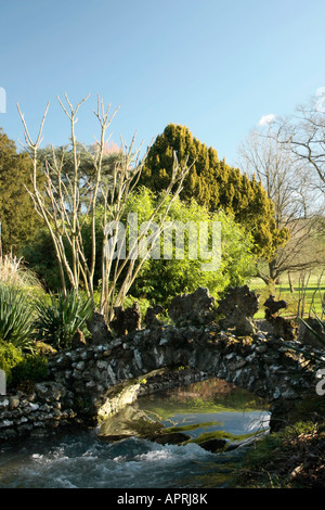 Ornamental stone bridge over stream in winter at West Dean Gardens, West Sussex, England Stock Photo