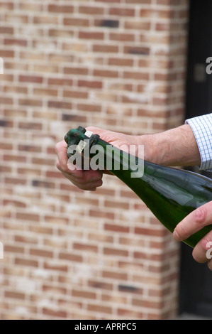 Herve Jestin, oenologist and chief winemaker holding a bottle of champagne Beuverie 1983 vintage that he will disgorge manually. The first step is to hold the bottle pointing upwards and remove the capsule cork Champagne Duval Leroy, Vertus, Cotes des Blancs, Champagne, Marne, Ardennes, France Stock Photo