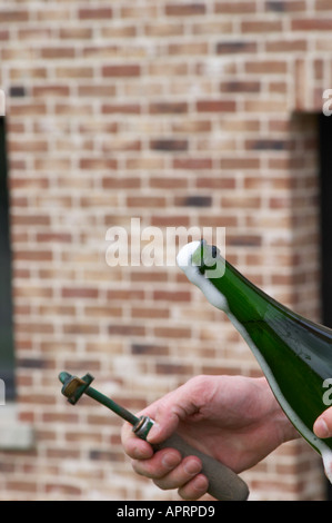 Herve Jestin, oenologist and chief winemaker holding a bottle of champagne Beuverie 1983 vintage that he will disgorge manually. After removing the capsule cork a little of the wine pours out of the bottle. This wine is then replaced by the liqueur d'expedition and the bottle is then recorked Champagne Duval Leroy, Vertus, Cotes des Blancs, Champagne, Marne, Ardennes, France Stock Photo