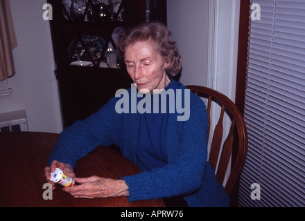 A woman examines medicine bottle Stock Photo