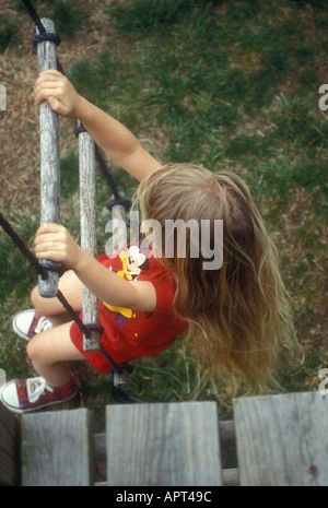 Little Girl climbing a Rope Ladder Stock Photo